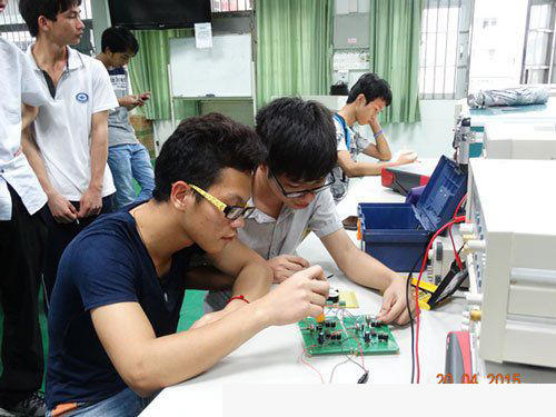关开朗和刘裕同学在学校实训室研讨调试电路